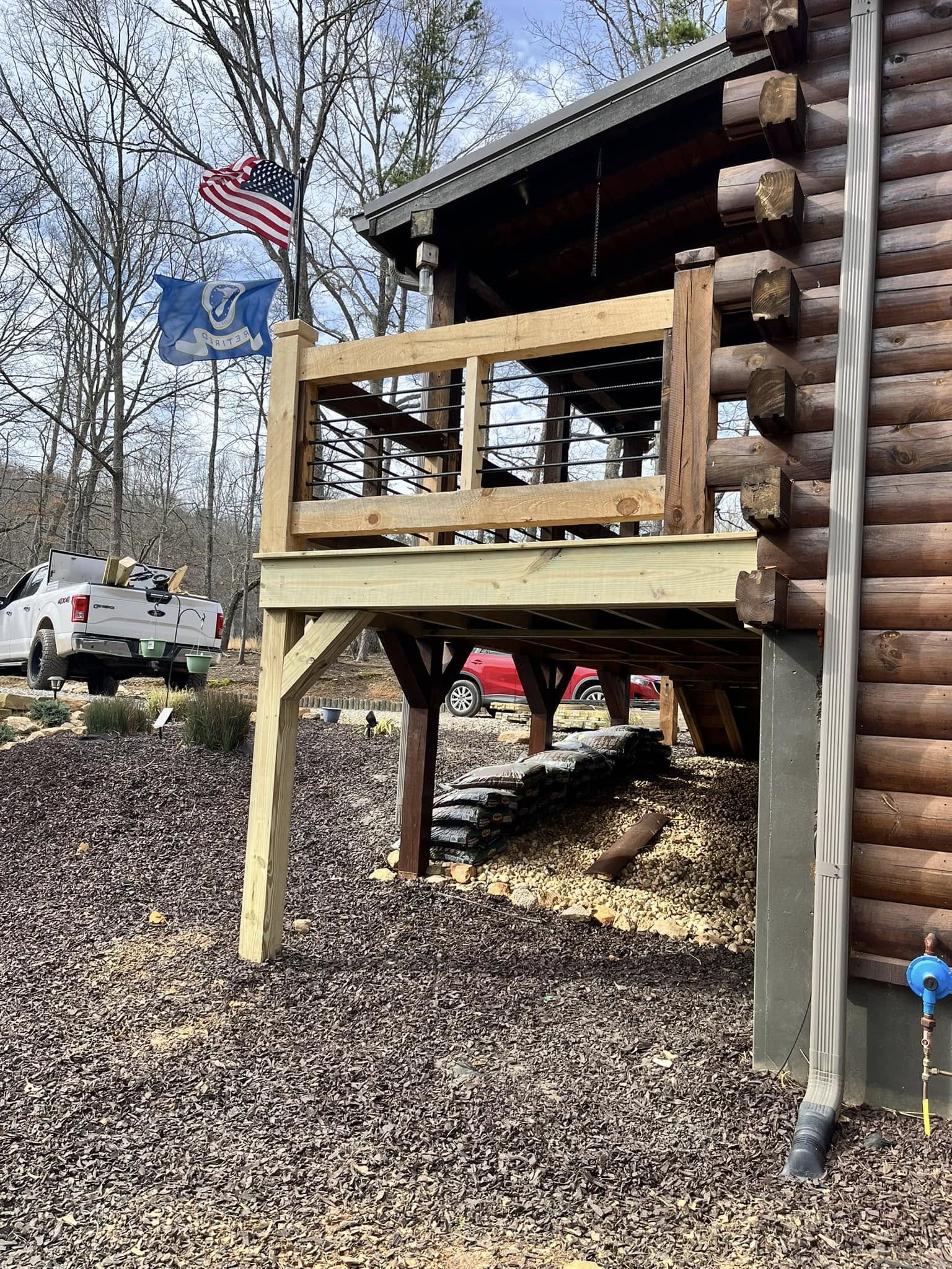 Custom wooden deck with metal railing on a log cabin in Blairsville, GA